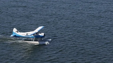 Blue and white float plane taxies out on dark blue water Stock Footage 208157109