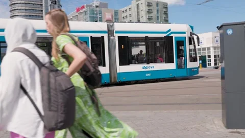 Blue and White GVB Tram Passing Pedestrians in Amsterdam Vidéo 314188458