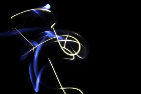 Blue and white light painting photography in a loop against a black background. Stock Photos