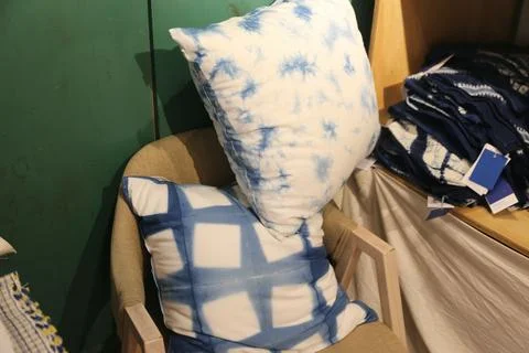 Blue and white patterned pillows arranged on an upholstered chair Stock Photos