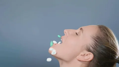 Blue and white pills fall into lady with ponytail mouth 库存影片 127954880