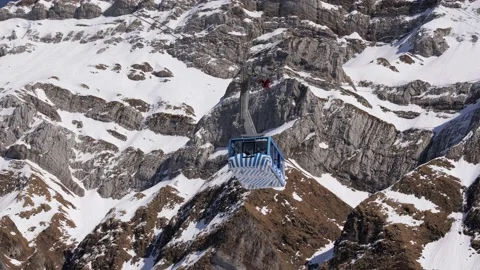 Blue and white sntis cable car on the way down, in the background snow mountain Stock Footage 166714993