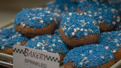 Blue And White Sprinkled Donuts On Display In Bakery Foto stock