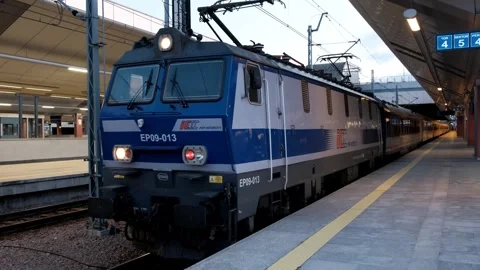 Blue and white train pulling into train station next to platform Video stock 245098194