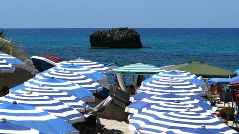 Blue and white umbrellas lined up close to the sea Video stock 113053983
