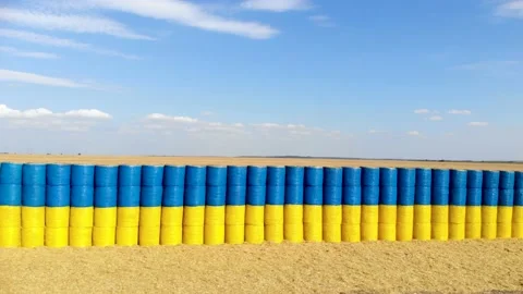 Blue and yellow flag made of hay bales on a wheat field with a blue sky. Stock Footage 138929637