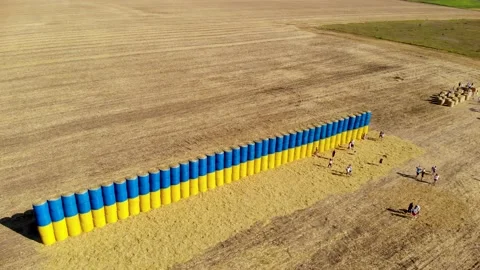 Blue and yellow flag made of hay bales on a wheat field with a blue sky. Stock Footage 139222709