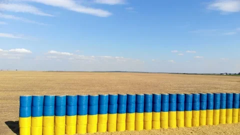 Blue and yellow flag made of hay bales on a wheat field with a blue sky. Stock Footage 139619207