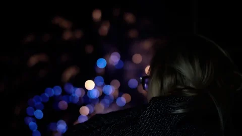 Blue and yellow flashes of fireworks that the girl looks at Stock Footage 130049537