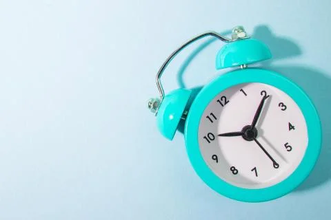 Blue background and blue alarm clock Foto stock