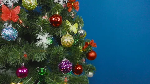 On a blue background, a beautiful Christmas tree decorated with various toys Stock Footage 147232622