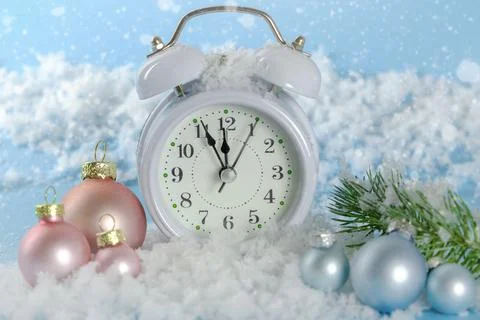 On a blue background - a clock in the snow. time from five minutes to midnigh Stock Photos