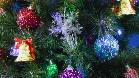 A blue background close-up with an approaching decoration on a Christmas tree Stock Footage 166705978