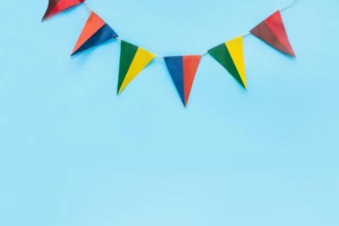 Blue background with flags, multi-colored triangular flags hanging at the top Stock Photos