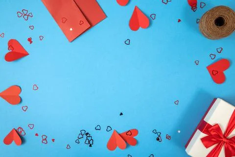 Blue background with gift, envelope and papper hearts Stock Photos