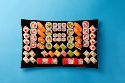 On blue background large black table with different types of sushi for a large Foto stock
