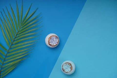 Blue background with a leaf of greenery and a bath bomb Stock Photos