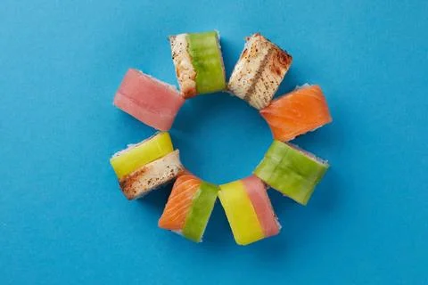 On blue background, multi-colored sushi laid out in a circle, different types of Stock Photos