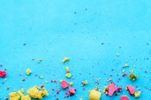 Blue background with multicolored cake crumbs, top view Foto stock