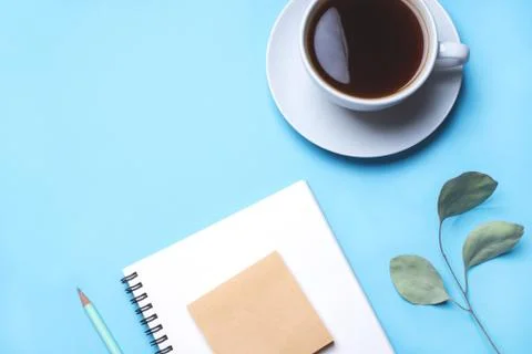 Blue background with notepad, pencil and cup of coffee. Stock-Fotos