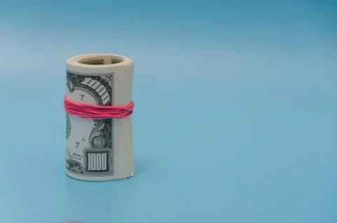 On a blue background pack of a thousand dollars tied with a rubber band, plac Fotos Stock