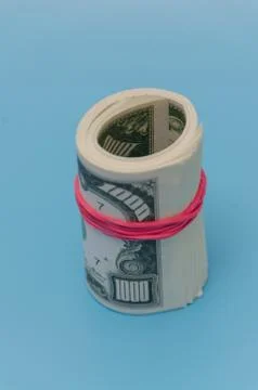 On a blue background pack of a thousand dollars tied with a rubber band 스톡 사진