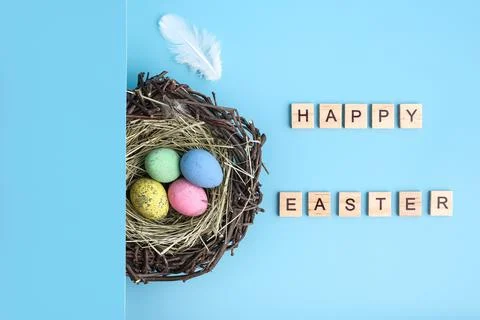 Blue background with painted easter egg nest flat lay Stock Photos