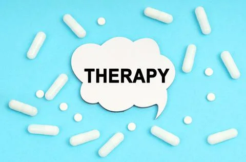 On a blue background pills and a plate. Inside the sign it says - THERAPY Stockfoto's