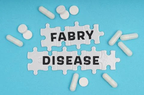 On a blue background pills and puzzles with the inscription - Fabry Disease Stock Photos