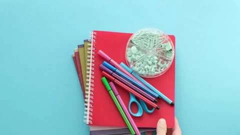 A blue background with a red notebook and a green object Stock Footage 315180093