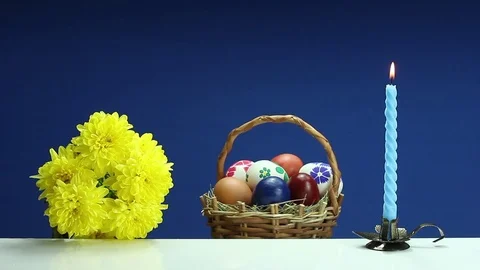	On a blue background revolves wicker basket with hand-painted Easter eggs Stock Footage 73104453