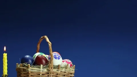 	On a blue background revolves wicker basket with hand-painted Easter eggs Stock Footage 73104454