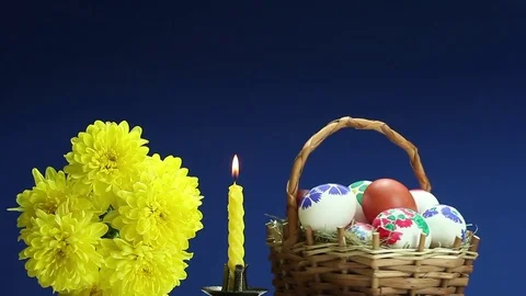 	On a blue background revolves wicker basket with hand-painted Easter eggs Stock Footage 73104463