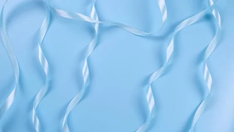 Blue background with satin ribbons, concept of boy and newborn birthday Stock Footage 195621292
