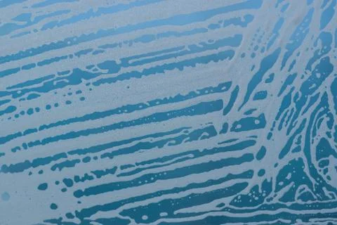 Blue background. Soap foam pattern and bubbles on glass. Stock Photos