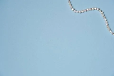 Blue background with string of pearls. Flat lay, top view. Copy space Stock Photos