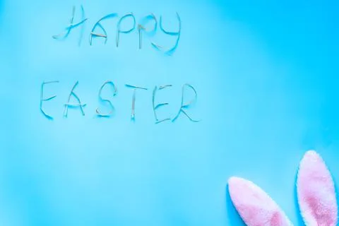 Blue background with text happy Easter and bunny ears Stock Photos