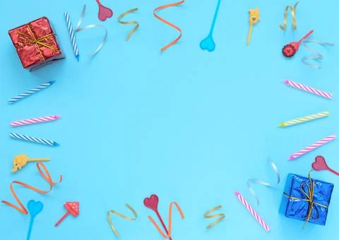 Blue background with wrapped giftboxes, streamers, candles and skewers. Birth 写真素材