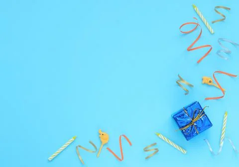 Blue background with wrapped giftboxes, streamers, candles and skewers. Birth Stock Photos