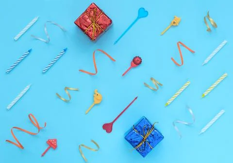 Blue background with wrapped giftboxes, streamers, candles and skewers. Birth Stock Photos