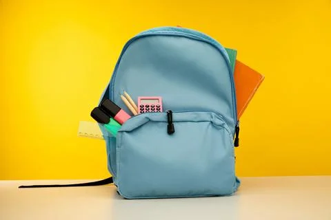 Blue backpack with different colorful stationery on table. Back to school Stock Photos