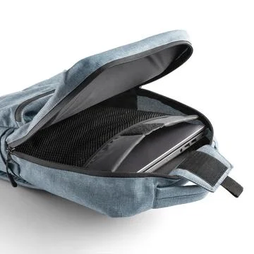Blue backpack with a laptop inside the open main compartment. White backgroun Stock Photos