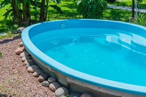 Blue Backyard Swimming Pool with Stone Border Stock Photos