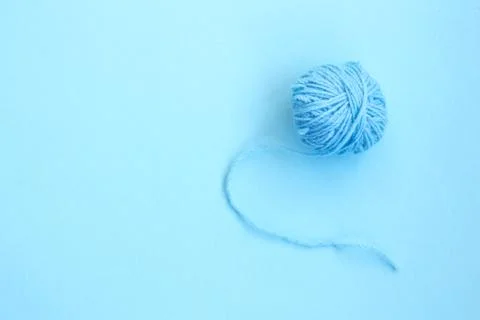 Blue ball of woolen thread on a blue background Stock Photos