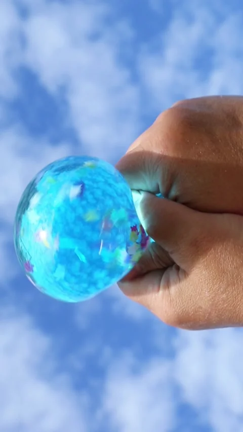 Blue balloon with beads pressed by hands under sky Stock Footage 317212159