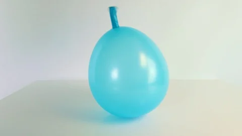 Blue balloon deflating in slow motion Stock Footage