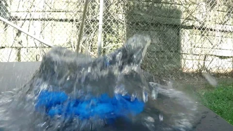 Blue balloon popping with a sharp bamboo stick in slow motion outdoor setup on Stock Footage 152236867