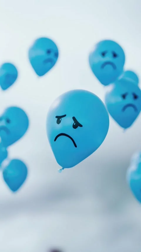 Blue balloons with sad faces float through a grey sky, symbolizing the gloo.. Stock Footage 325872840
