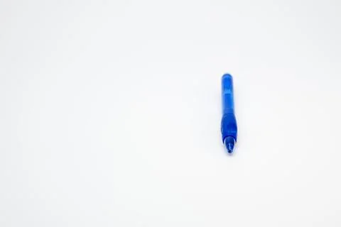 Blue ballpoint pen standing vertically on white background Fotos de archivo