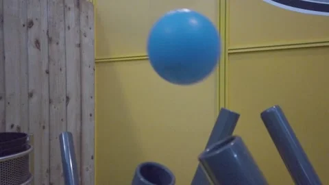 Blue Balls Float in Air Over Tubes Yellow Background Stock Footage 236480860